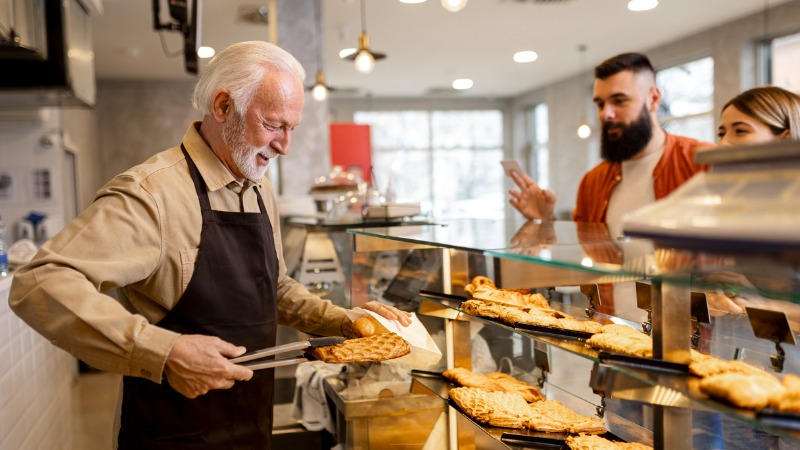 gepensioneerde man werkt in winkel om pensioenbonus te krijgen